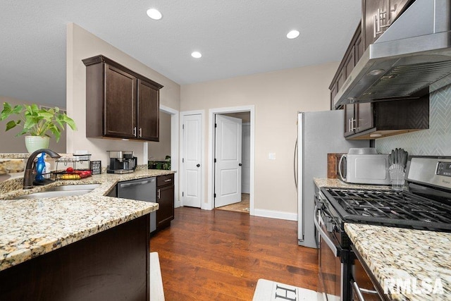 67 Cobblestone Ln, Le Claire, IA 52753 - kitchen with stainless steel appliances, under cabinet range hood, dark brown cabinets, light stone countertops, and dark wood finished floors