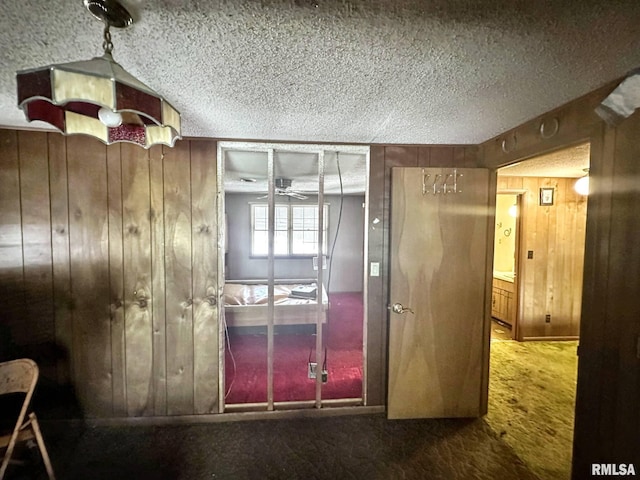 900 E 4th St, West Frankfort, IL 62896 - hallway featuring carpet, wooden walls, and a textured ceiling