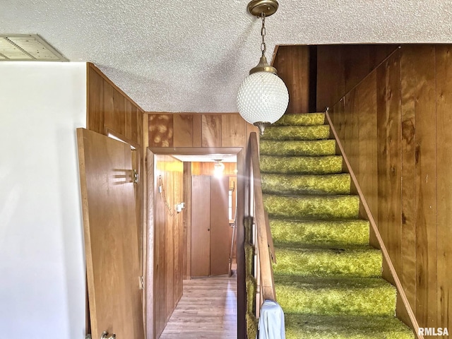 900 E 4th St, West Frankfort, IL 62896 - stairway featuring a textured ceiling, wood finished floors, and wood walls