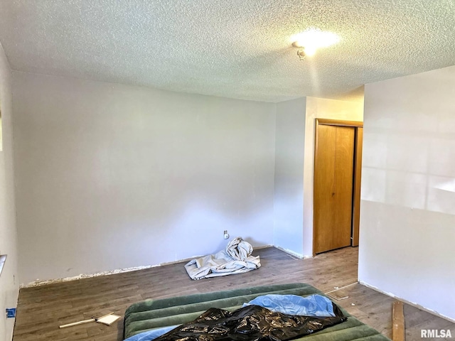 900 E 4th St, West Frankfort, IL 62896 - unfurnished bedroom featuring wood finished floors, a textured ceiling, and a closet
