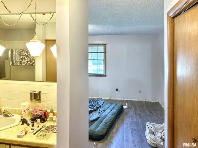 900 E 4th St, West Frankfort, IL 62896 - bathroom with a textured ceiling, wood finished floors, tasteful backsplash, and vanity