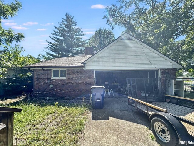 900 E 4th St, West Frankfort, IL 62896 - view of home's exterior featuring brick siding, a chimney, and an attached garage