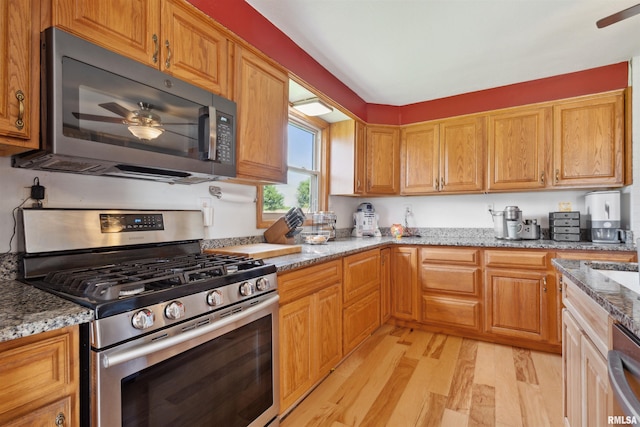 829 Union Ave, Lowden, IA 52255 - kitchen featuring stainless steel appliances, light wood-style floors, ceiling fan, and light stone counters
