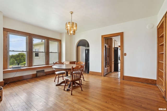 829 Union Ave, Lowden, IA 52255 - dining space with arched walkways, light wood finished floors, and a chandelier
