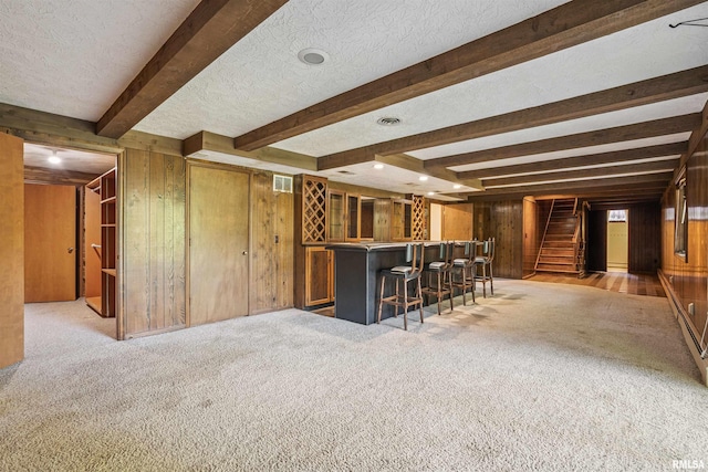 2351 5th St, East Moline, IL 61244 - indoor dry bar featuring wooden walls, beam ceiling, light colored carpet, stairway, and a textured ceiling