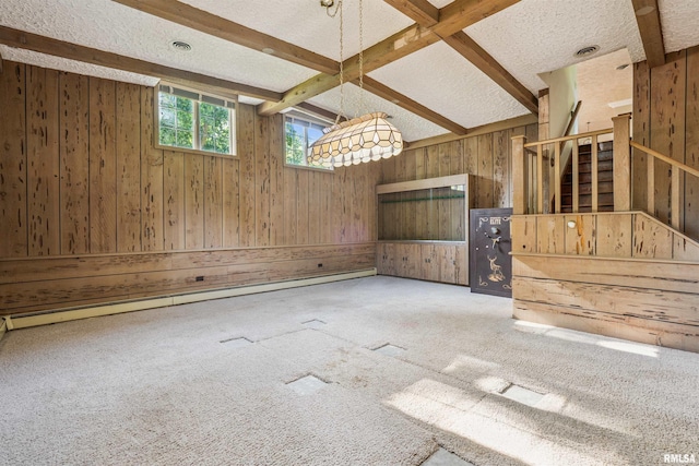 2351 5th St, East Moline, IL 61244 - unfurnished dining area with wood walls, a textured ceiling, beam ceiling, carpet flooring, and a baseboard radiator