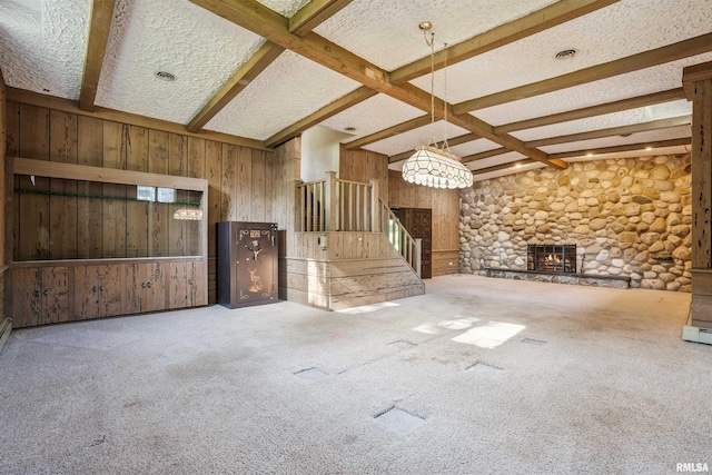 2351 5th St, East Moline, IL 61244 - unfurnished living room featuring stairway, wooden walls, beamed ceiling, carpet flooring, and a fireplace