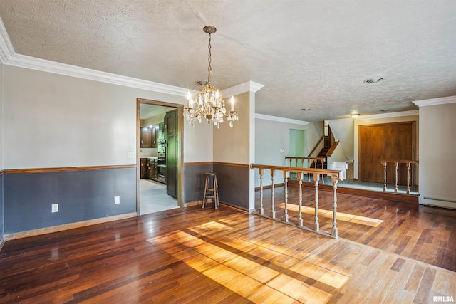 2351 5th St, East Moline, IL 61244 - empty room featuring hardwood / wood-style flooring, a chandelier, a textured ceiling, ornamental molding, and a baseboard radiator