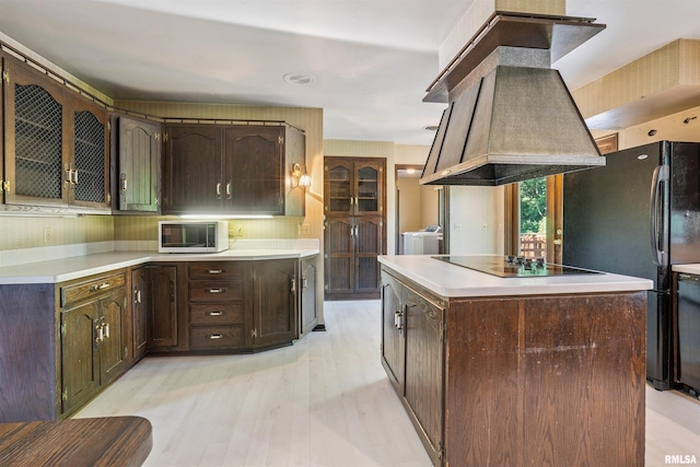 2351 5th St, East Moline, IL 61244 - kitchen with black appliances, ventilation hood, washing machine and dryer, light countertops, and dark brown cabinetry