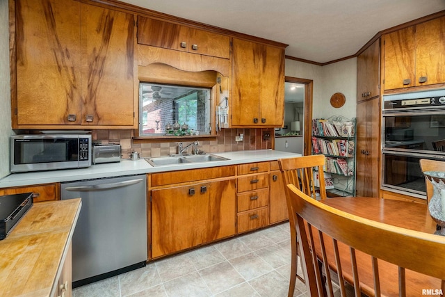 613 S Locust, West Frankfort, IL 62896 - kitchen with appliances with stainless steel finishes, brown cabinets, crown molding, butcher block counters, and tasteful backsplash