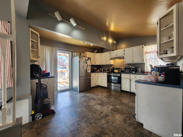 3217 18th Ave, Rock Island, IL 61201 - kitchen featuring stainless steel appliances, dark countertops, under cabinet range hood, white cabinets, and dark stone finish flooring