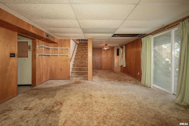 2518 13th St, Rock Island, IL 61201 - basement featuring wood walls, stairs, carpet floors, and a paneled ceiling