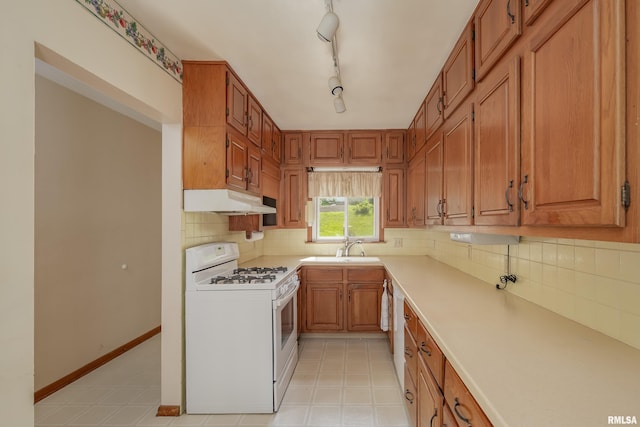 2518 13th St, Rock Island, IL 61201 - kitchen featuring white range with gas cooktop, under cabinet range hood, light countertops, decorative backsplash, and brown cabinetry