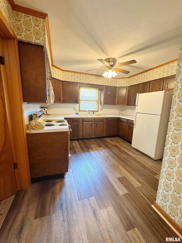 208BAGGOTT None St, Zeigler, IL 62999 - kitchen featuring white appliances, wallpapered walls, dark wood-style flooring, light countertops, and a ceiling fan
