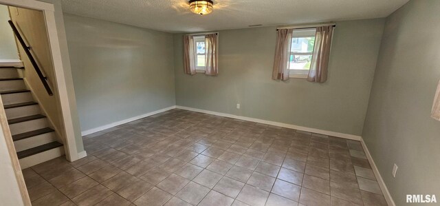 2337 Cameron Dr, Clinton, IA 52732 - tiled spare room with a textured ceiling and stairway
