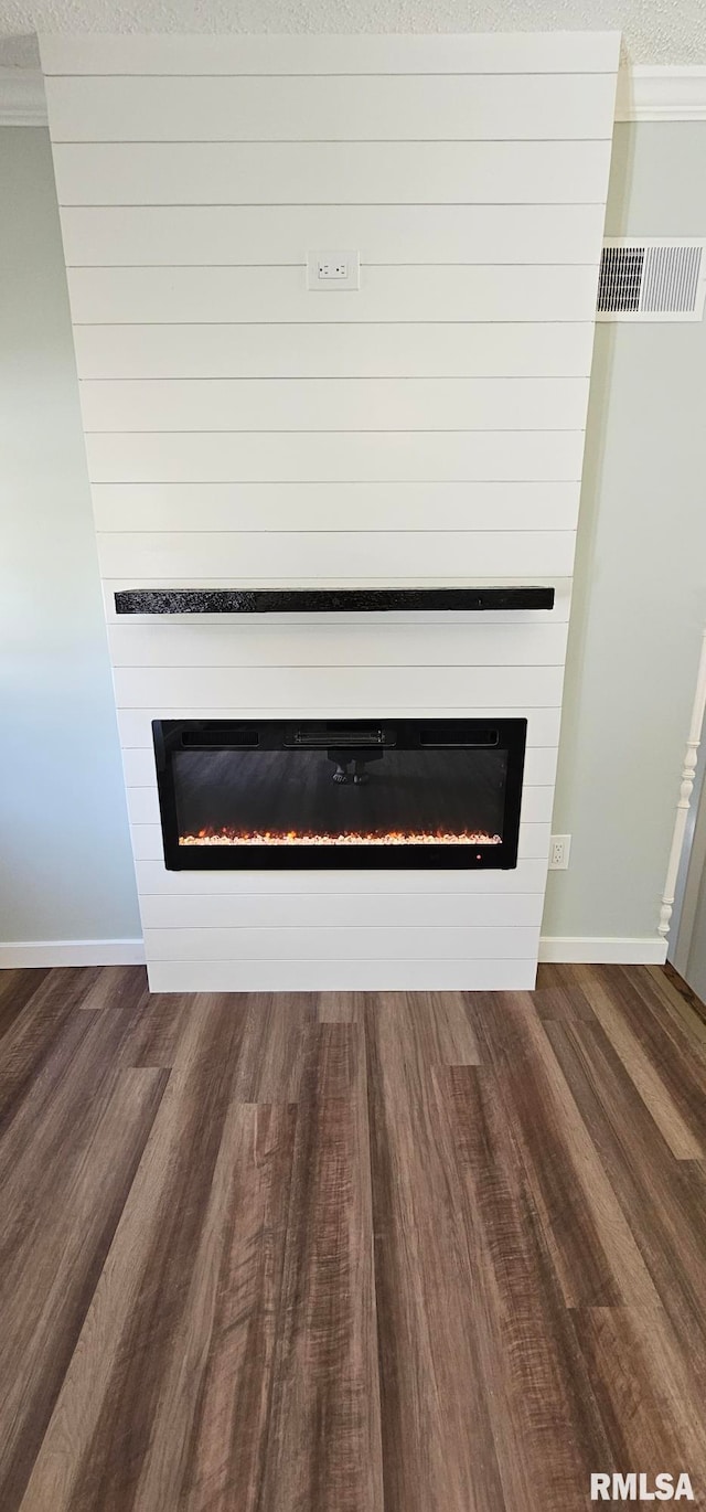 2337 Cameron Dr, Clinton, IA 52732 - detailed view of a large fireplace, wood finished floors, and crown molding