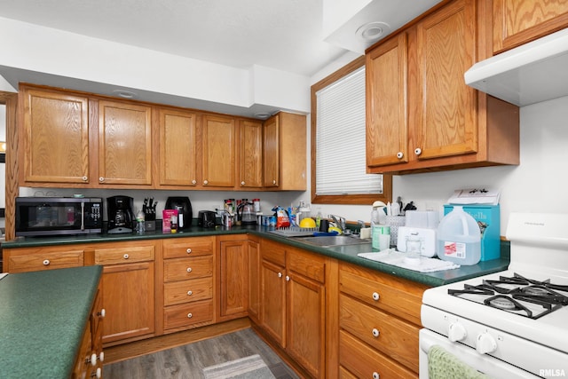 222 6th St, Buffalo, IA 52728 - kitchen featuring white gas stove, stainless steel microwave, ventilation hood, and brown cabinets