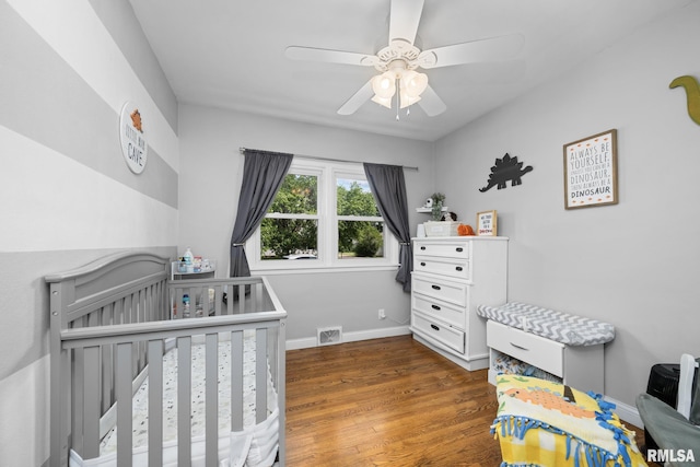 4040 27th Ave, Rock Island, IL 61201 - bedroom featuring a nursery area, wood finished floors, and a ceiling fan