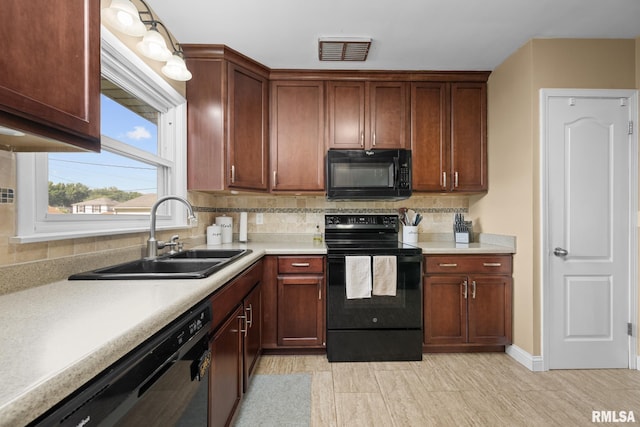 4040 27th Ave, Rock Island, IL 61201 - kitchen featuring black appliances, light countertops, and backsplash