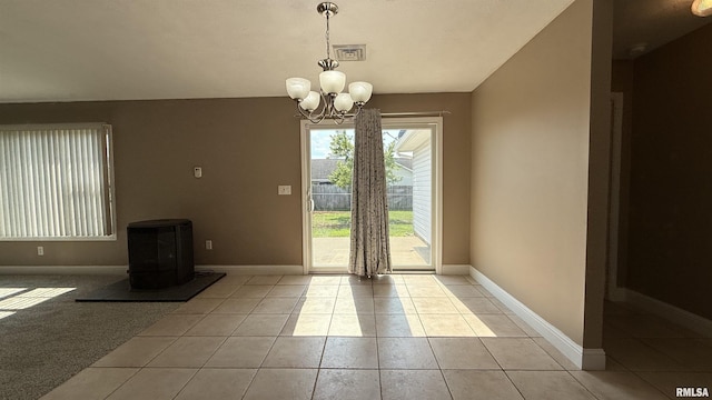 11279 Nora Ln, Carterville, IL 62918 - doorway to outside featuring light tile patterned flooring, a chandelier, and a wood stove