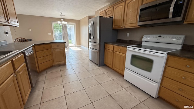 11279 Nora Ln, Carterville, IL 62918 - kitchen featuring stainless steel appliances, dark countertops, a textured ceiling, a chandelier, and light tile patterned floors