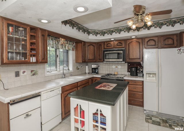 8527 W 17th St, Rock Island, IL 61201 - kitchen featuring white appliances, a ceiling fan, light tile patterned floors, backsplash, and glass insert cabinets