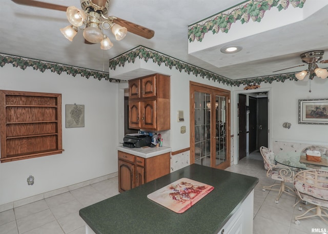 8527 W 17th St, Rock Island, IL 61201 - kitchen with a ceiling fan, light tile patterned floors, french doors, brown cabinets, and dark countertops