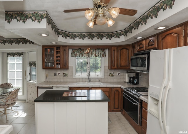 8527 W 17th St, Rock Island, IL 61201 - kitchen featuring appliances with stainless steel finishes, light tile patterned flooring, a ceiling fan, and tasteful backsplash
