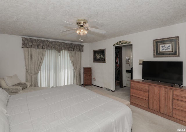 8527 W 17th St, Rock Island, IL 61201 - bedroom featuring light carpet, a closet, ceiling fan, a walk in closet, and a textured ceiling
