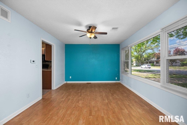 2043 30th St, Rock Island, IL 61201 - spare room with wood finished floors, a ceiling fan, and a textured ceiling