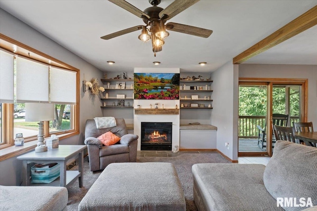 129 Glenview Dr, Sherrard, IL 61281 - carpeted living area with healthy amount of natural light, ceiling fan, a glass covered fireplace, and beam ceiling