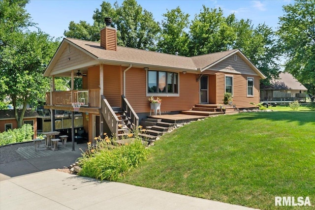 129 Glenview Dr, Sherrard, IL 61281 - view of front facade featuring a front yard, a chimney, a ceiling fan, a patio area, and a shingled roof
