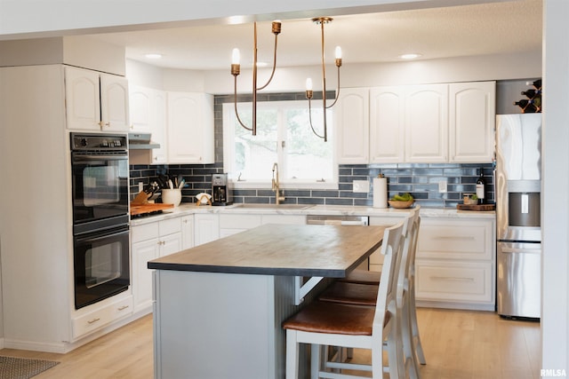 300 S 1st St, Camp Point, IL 62320 - kitchen with stainless steel fridge, light wood-style flooring, decorative backsplash, white cabinets, and recessed lighting