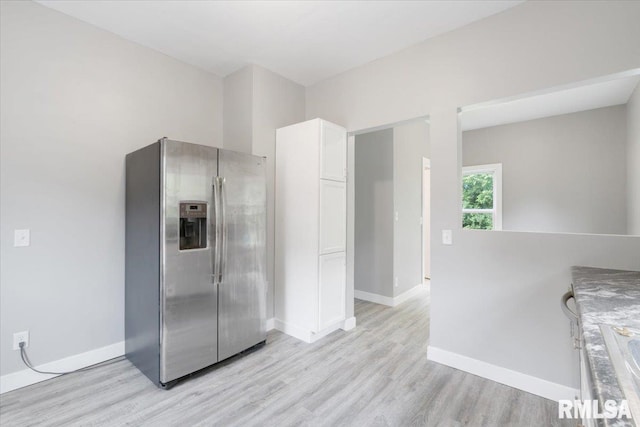 619 51st St, Moline, IL 61265 - kitchen with stainless steel fridge, light wood-style flooring, and white cabinetry