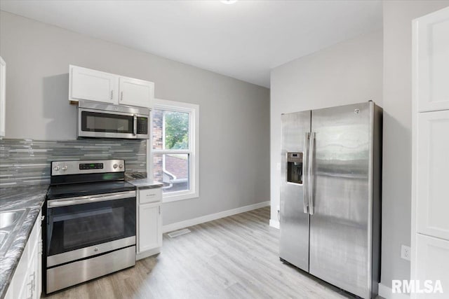 619 51st St, Moline, IL 61265 - kitchen with stainless steel appliances, white cabinetry, light wood finished floors, and backsplash