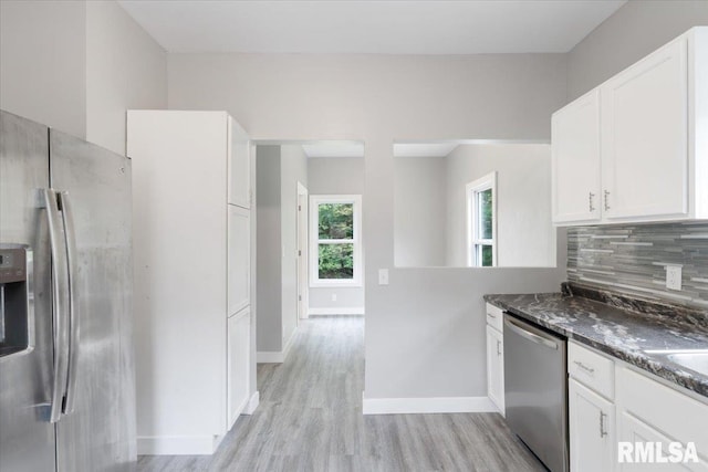 619 51st St, Moline, IL 61265 - kitchen with appliances with stainless steel finishes, light wood-type flooring, backsplash, and white cabinetry
