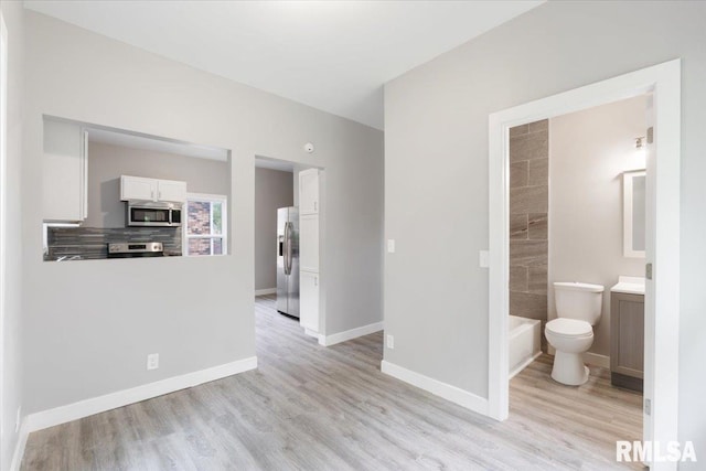 619 51st St, Moline, IL 61265 - unfurnished living room with light wood-style floors and baseboards