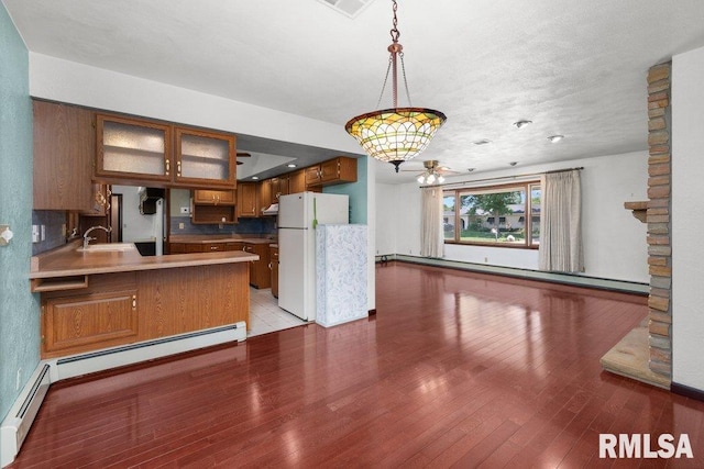 22 Pleasant View Dr, Annawan, IL 61234 - kitchen featuring freestanding refrigerator, brown cabinetry, light wood-style floors, and a baseboard radiator