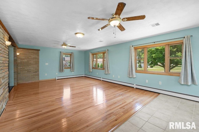 22 Pleasant View Dr, Annawan, IL 61234 - empty room featuring a ceiling fan, light wood-style flooring, brick wall, and a baseboard radiator