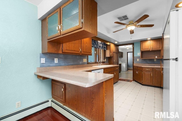 22 Pleasant View Dr, Annawan, IL 61234 - kitchen featuring a peninsula, decorative backsplash, a ceiling fan, brown cabinets, and a textured wall