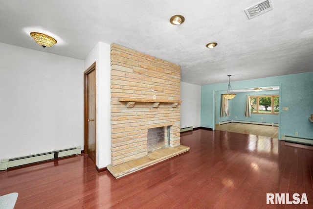 22 Pleasant View Dr, Annawan, IL 61234 - unfurnished living room with a baseboard radiator, a baseboard heating unit, wood finished floors, and a stone fireplace