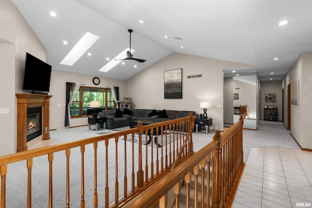 12828 25th Street Ct, Milan, IL 61264 - living area with light carpet, a skylight, vaulted ceiling, a glass covered fireplace, and recessed lighting