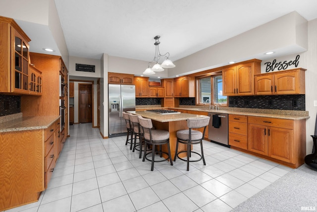 12828 25th Street Ct, Milan, IL 61264 - kitchen featuring appliances with stainless steel finishes, a breakfast bar, glass insert cabinets, backsplash, and a center island