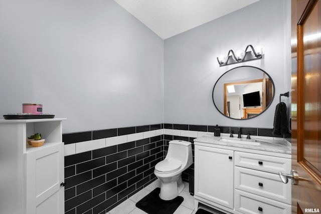 12828 25th Street Ct, Milan, IL 61264 - bathroom featuring vanity, tile patterned floors, tile walls, wainscoting, and vaulted ceiling