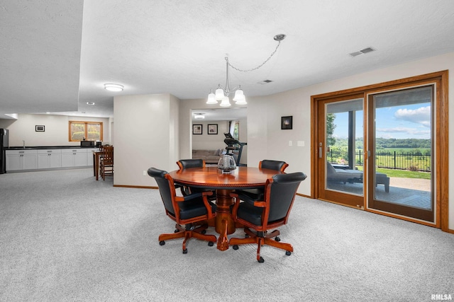 12828 25th Street Ct, Milan, IL 61264 - dining area featuring a chandelier, carpet flooring, and a textured ceiling