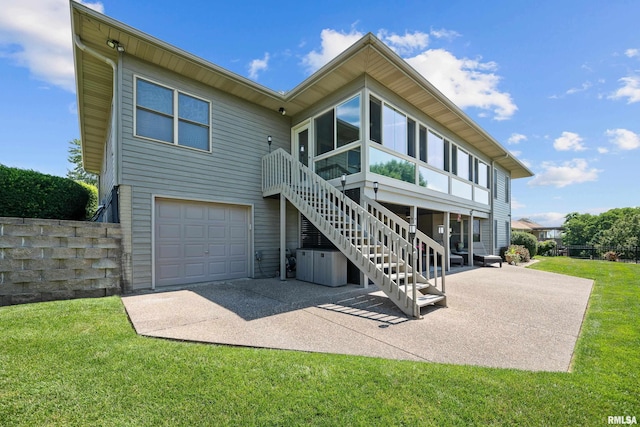 12828 25th Street Ct, Milan, IL 61264 - back of property featuring an attached garage, a lawn, a patio, and stairway