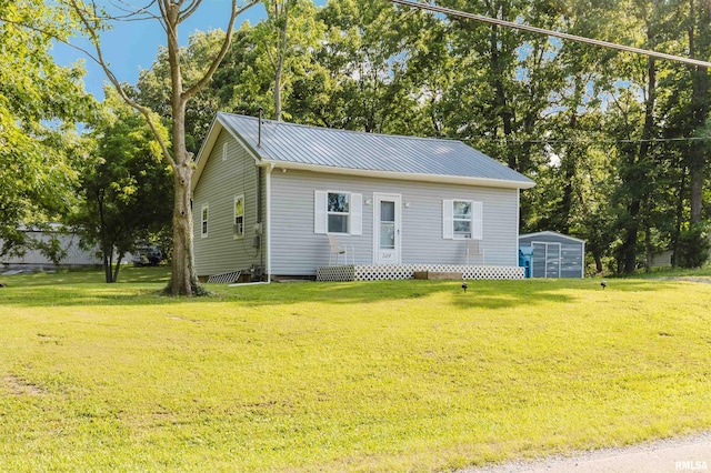 504 E Vermont St, Carterville, IL 62918 - view of front of home with a shed, a front yard, a metal roof, and view of wooded area