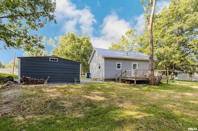 504 E Vermont St, Carterville, IL 62918 - rear view of property with a deck, a lawn, a metal roof, and a storage unit