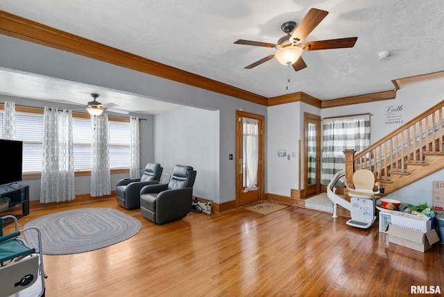 2016 12th St, Rock Island, IL 61201 - living room featuring ceiling fan, wood finished floors, stairway, a textured ceiling, and crown molding