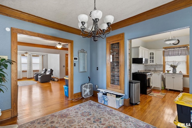 2016 12th St, Rock Island, IL 61201 - dining room featuring light wood-style floors, a chandelier, crown molding, ceiling fan, and a textured ceiling